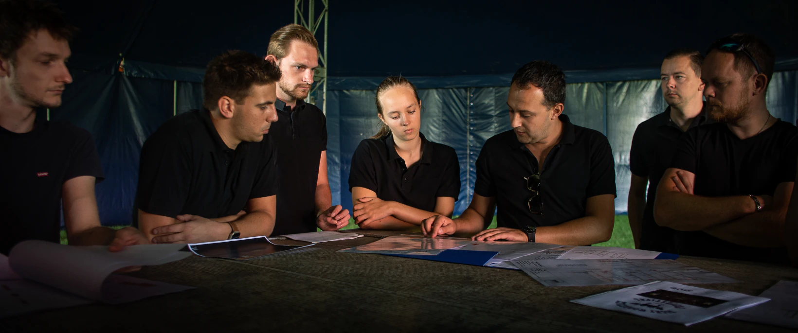 Productieteam stemt de technische uitvoering van een evenement af aan de hand van bouwtekeningen.